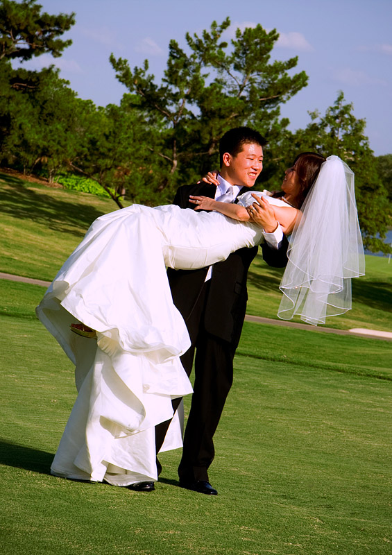 groom is carrying the bride at a country club in Plano Texas