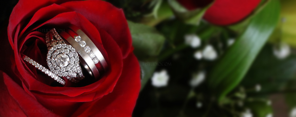 wedding rings engagement rings and wedding bands on a red rose 