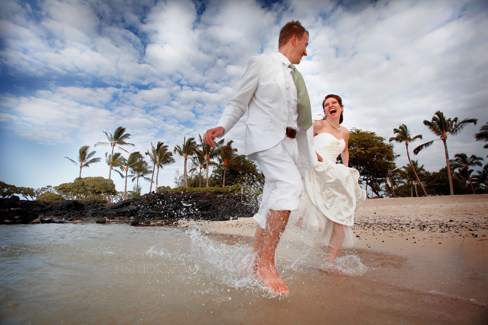 couple running on the beach hawaii big island water splash 